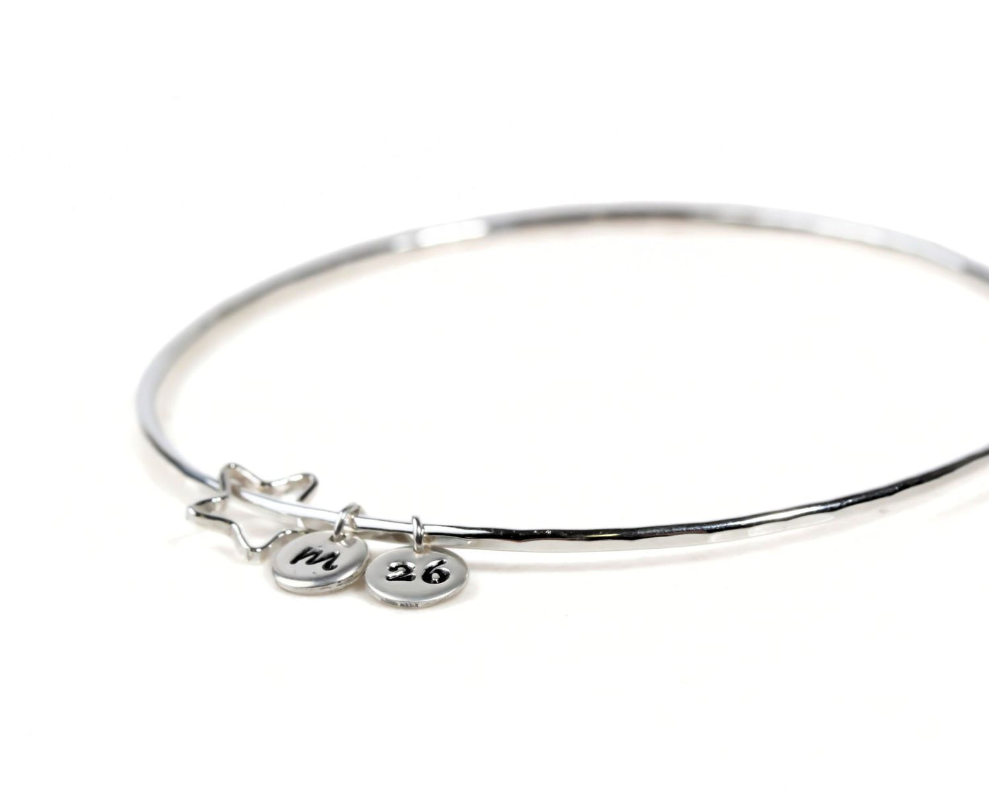 A silver bangle bracelet with charms and charms attached to it.