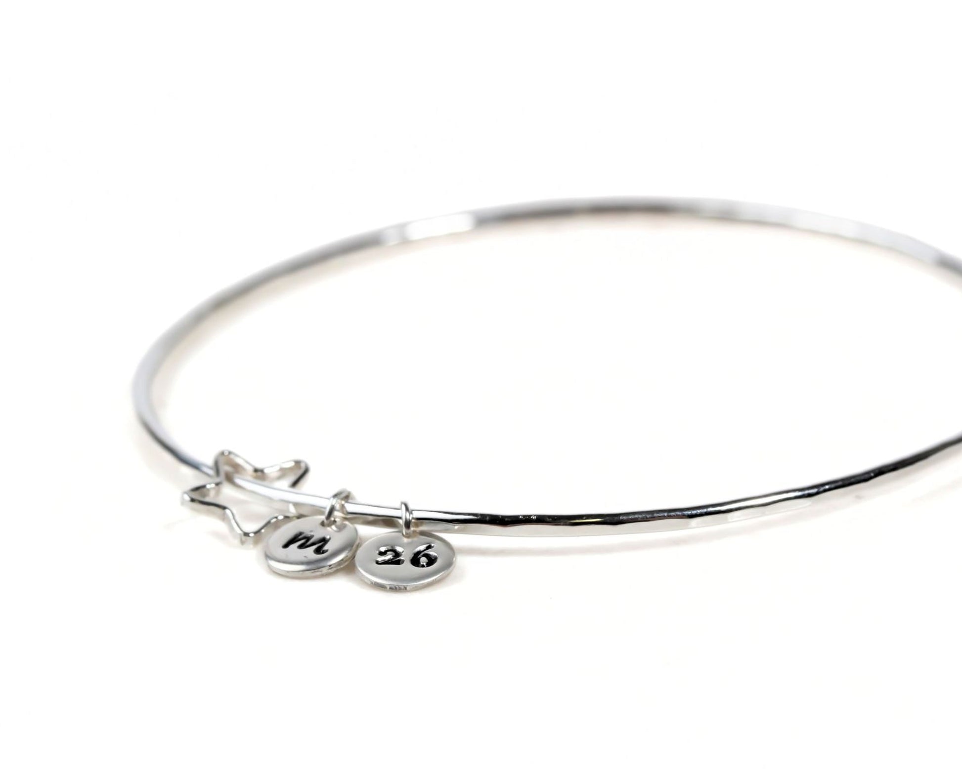 A silver bangle bracelet with charms and charms attached to it.