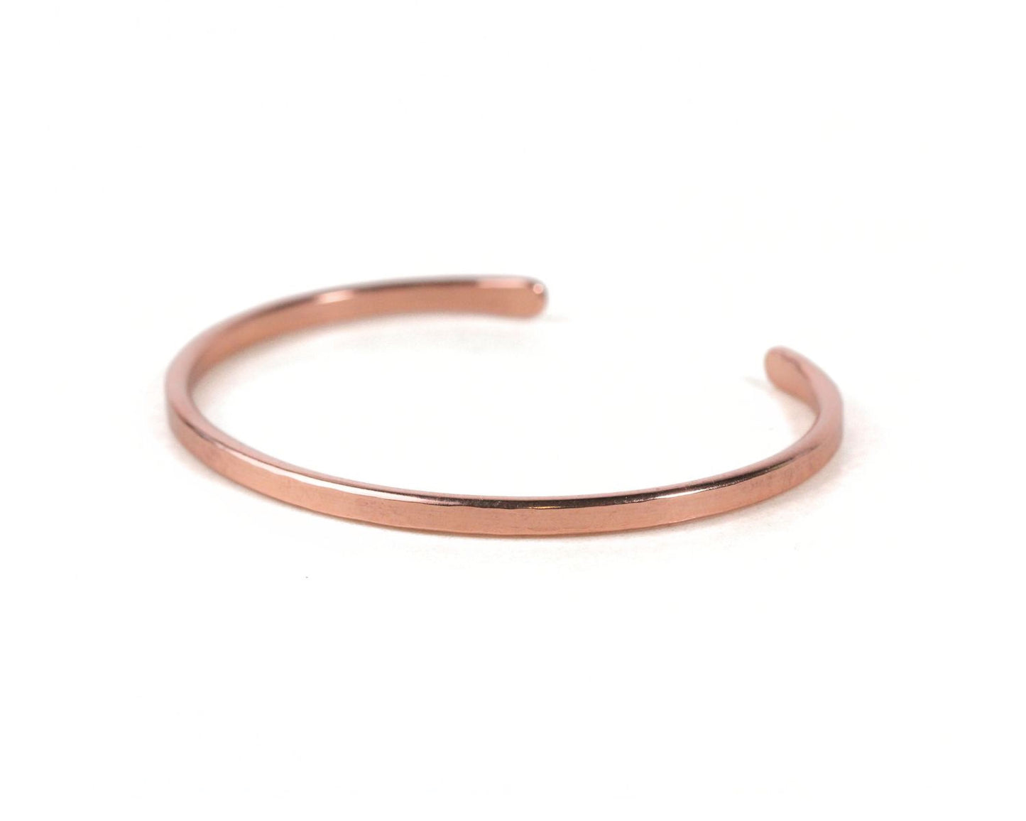 A copper-colored bracelet is shown against a white background.