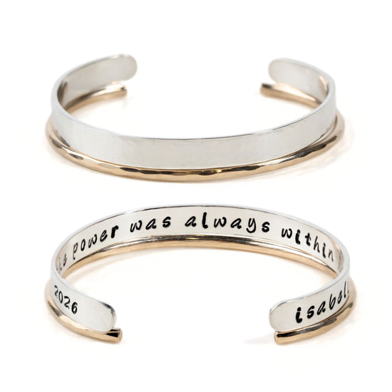 two silver bracelets with engraved text on them.