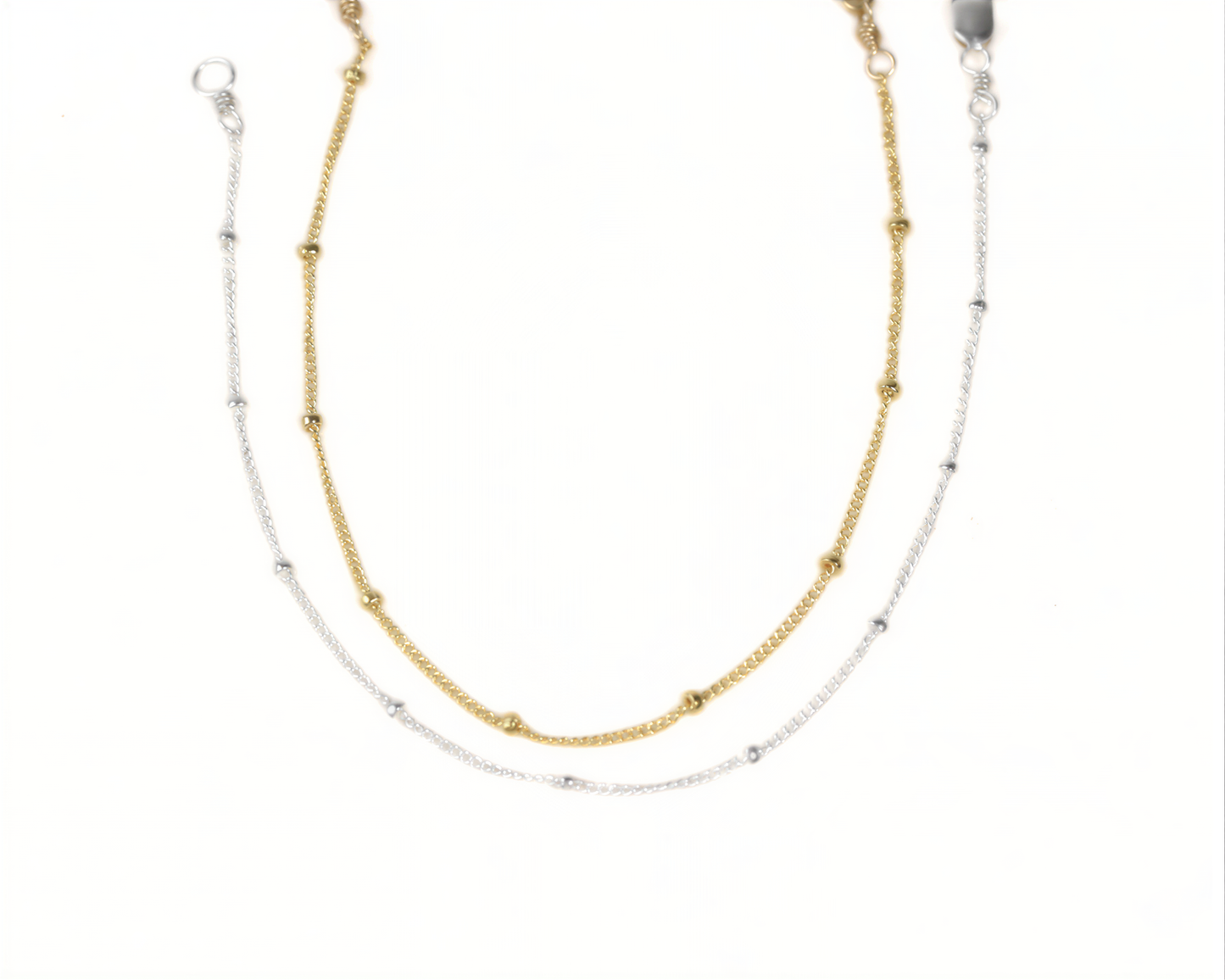 A necklace with two strands of beads, one gold and one silver, arranged in a layered design.