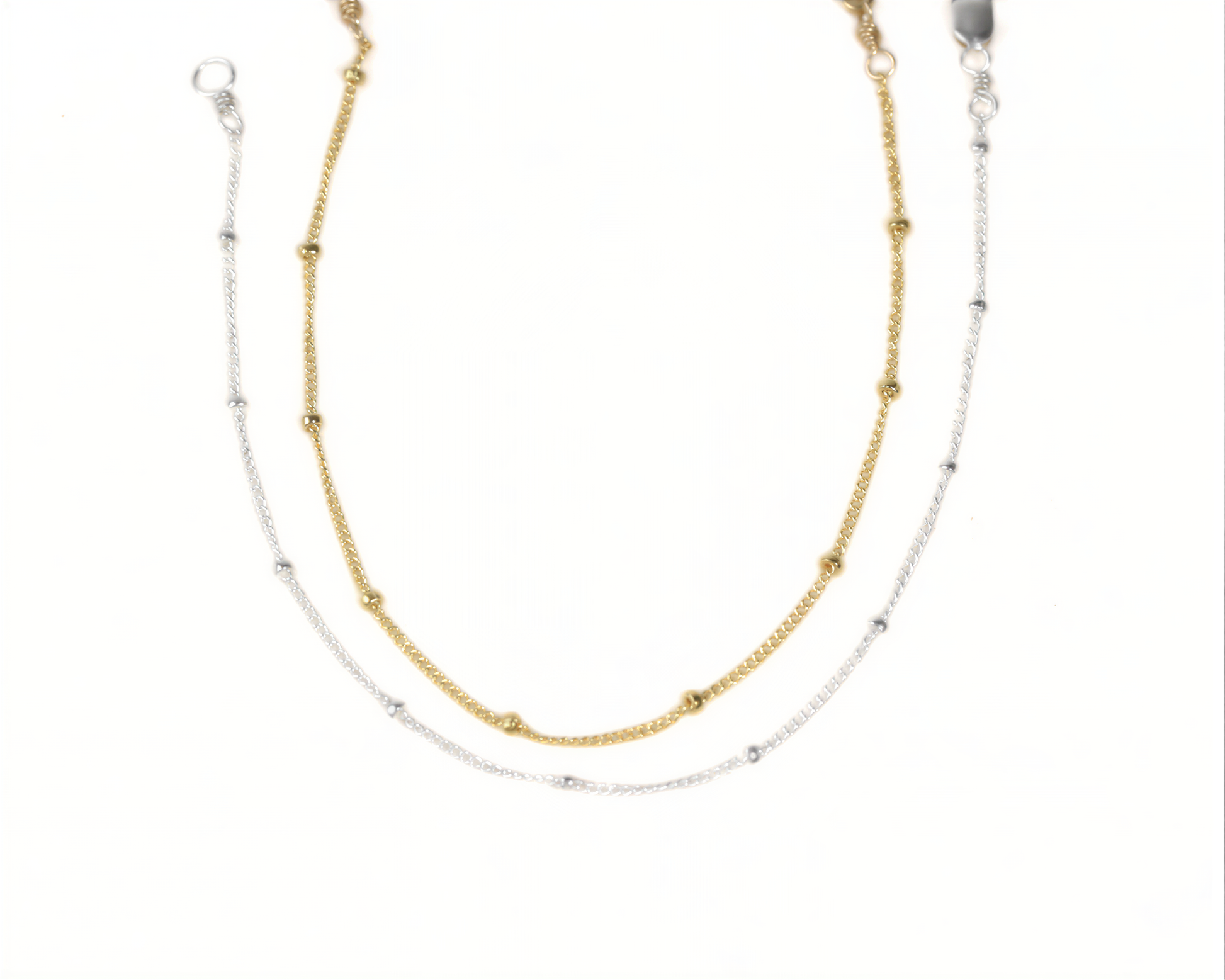 A necklace with two strands of beads, one gold and one silver, arranged in a layered design.