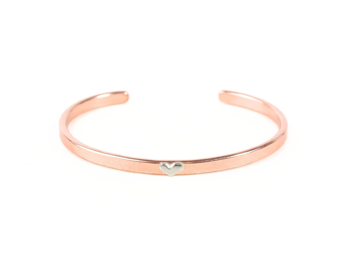 A copper-colored bracelet with a heart-shaped charm on it.