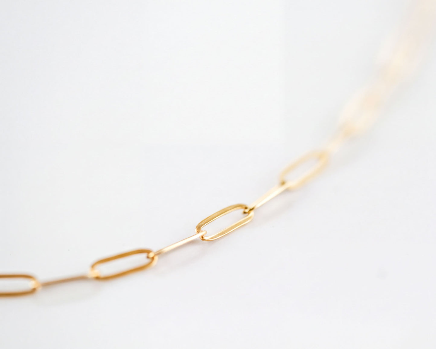 A close-up view of a gold chain necklace with multiple links.