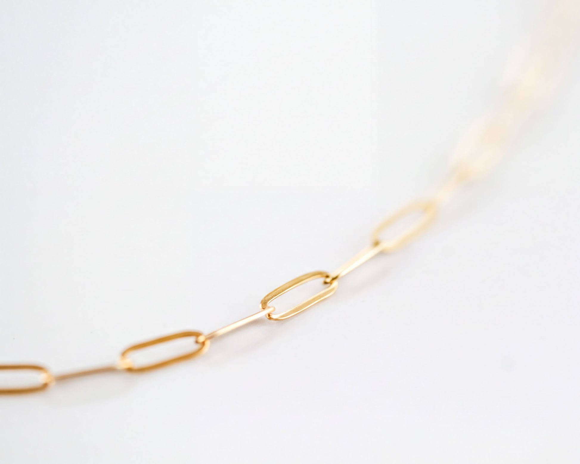 A close-up view of a gold chain necklace with multiple links.