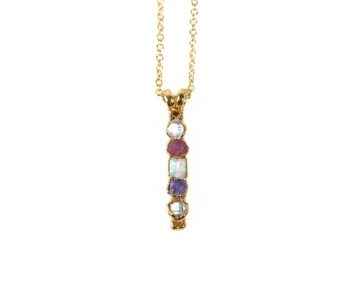 A gold necklace with a pendant featuring a row of colorful gemstones.