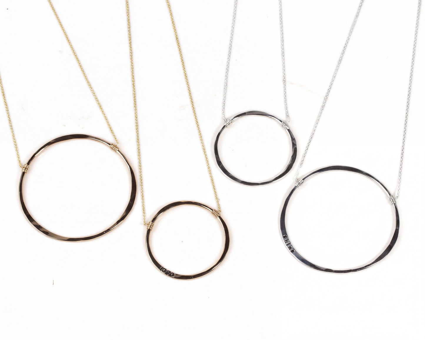 four circular necklaces with different designs and sizes, arranged on a white background.