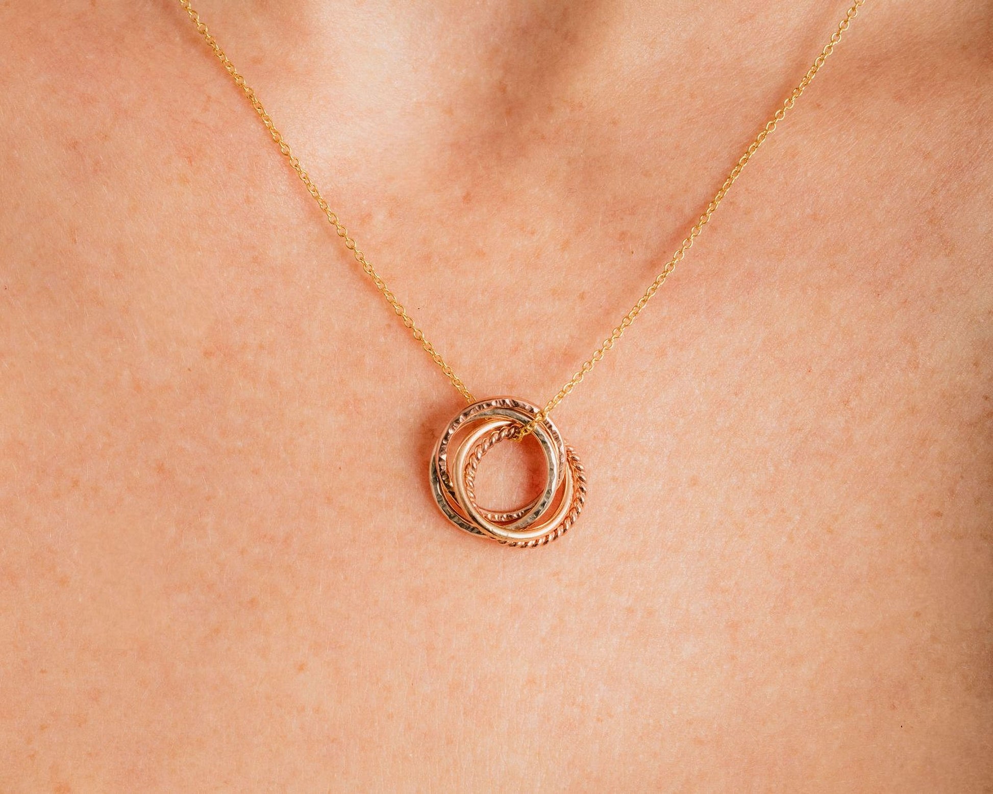 A close-up view of a gold necklace with a pendant featuring a circular design.