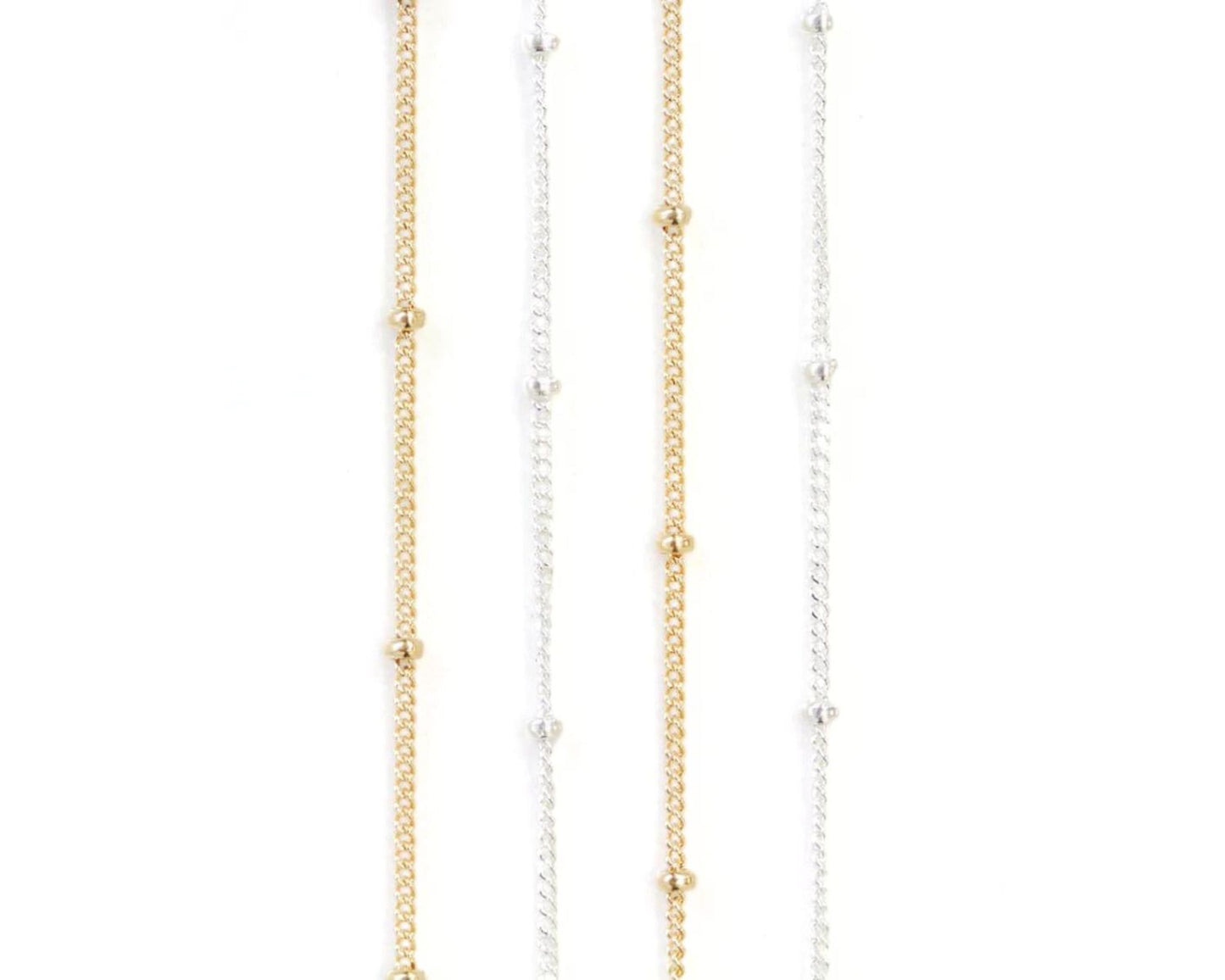 a collection of necklaces with gold and silver chains and small round beads.