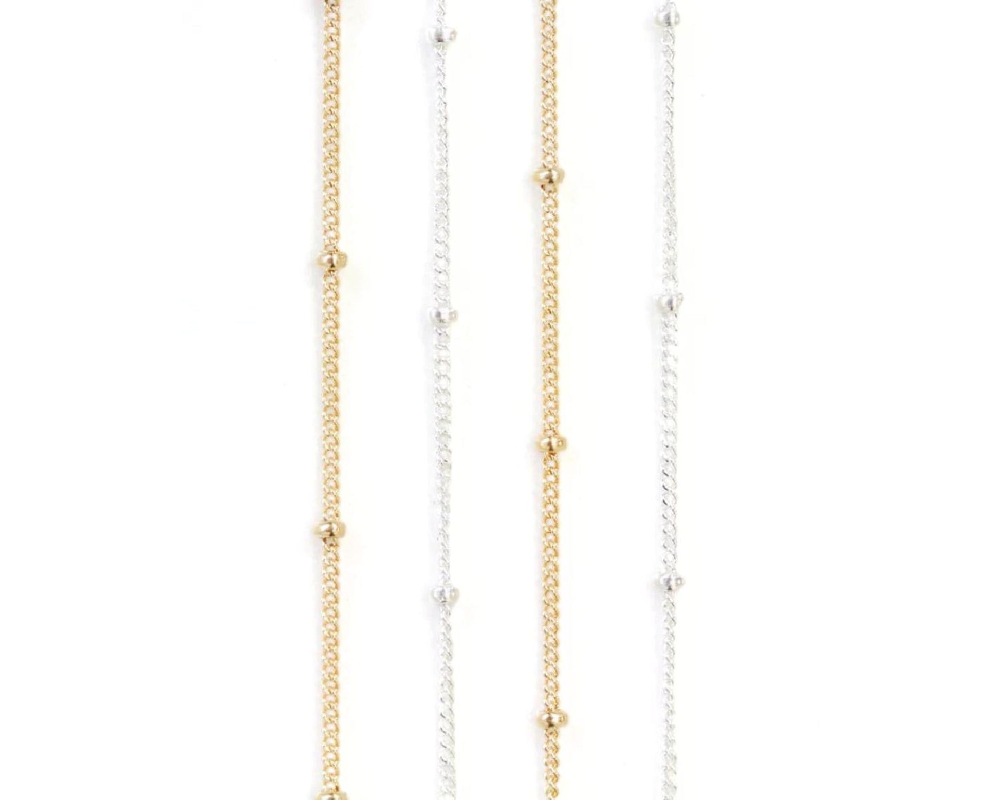 a collection of necklaces with gold and silver chains and small round beads.