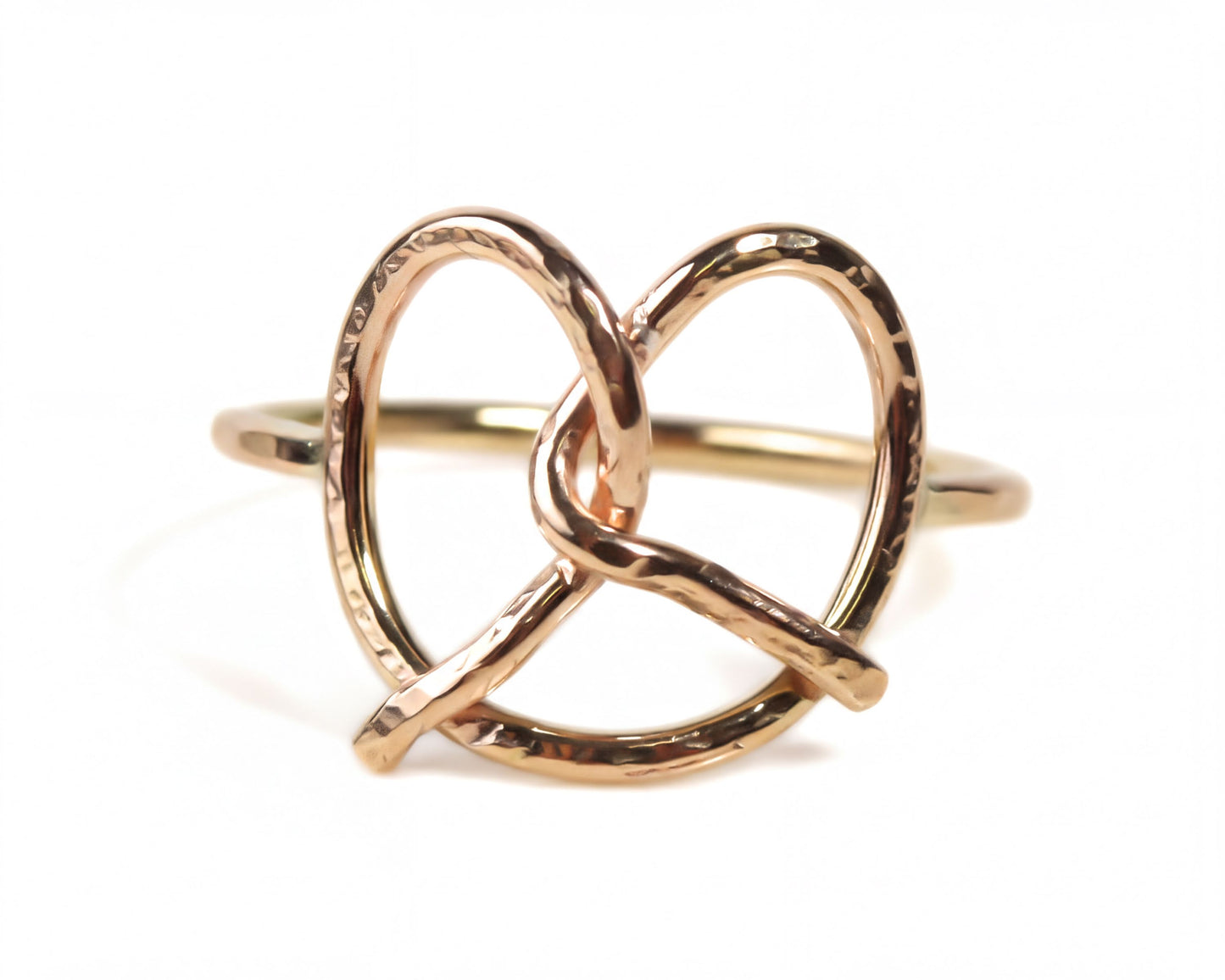 A gold-colored ring with a twisted, braided design resembling a pretzel.