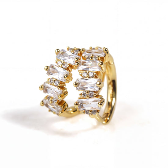 A gold earring with a row of clear gemstones, including diamonds, set in a decorative manner.