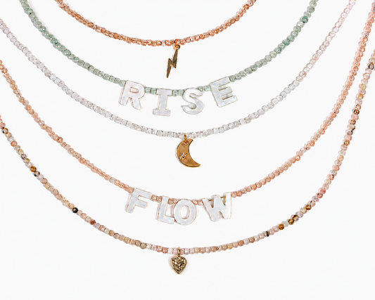 A collection of beaded necklaces with the words "RISE FLOW" spelled out in large letters.