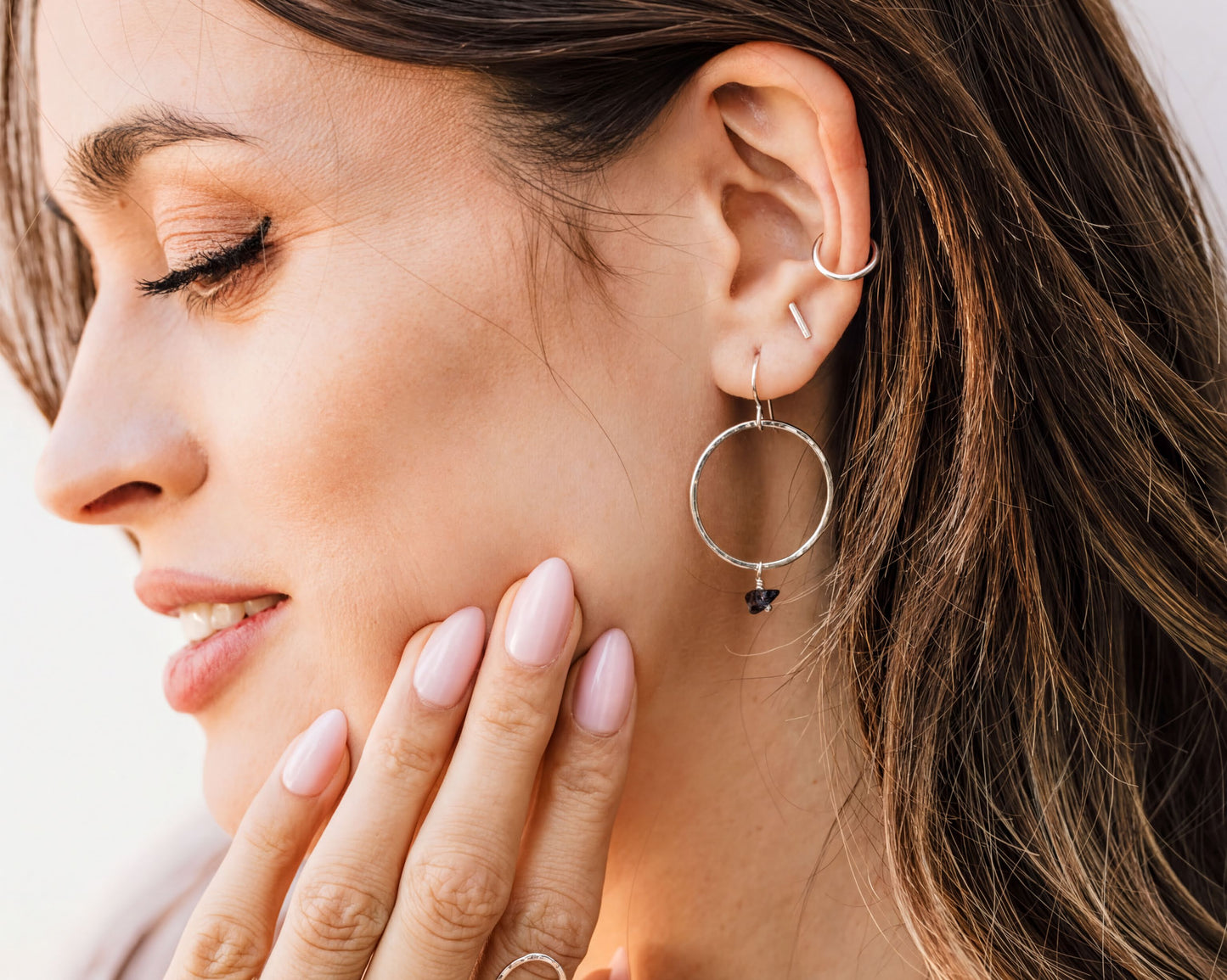A close-up of a woman's face, focusing on her eyes and earrings.