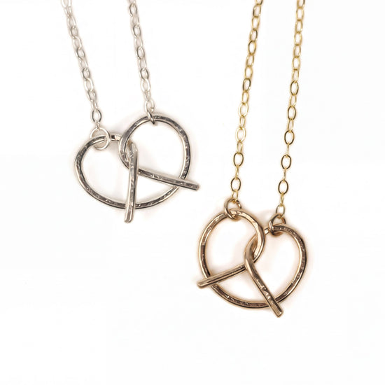Two necklaces with heart-shaped pendants are shown against a white background.