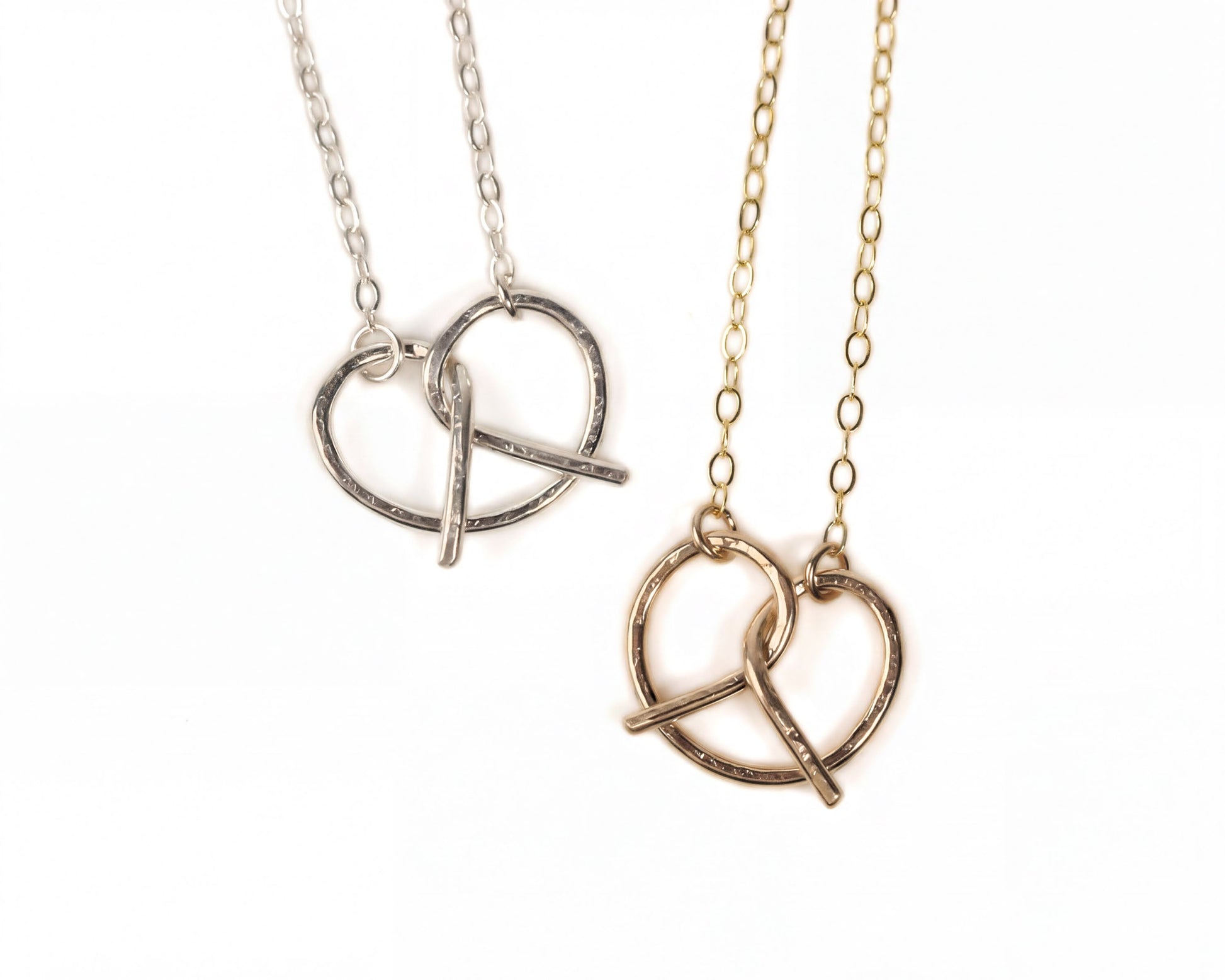 Two necklaces with heart-shaped pendants are shown against a white background.