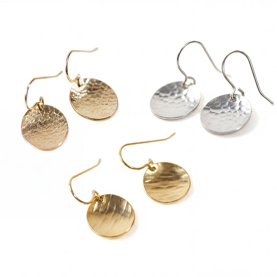 a collection of four earrings, each with a unique design and color. The earrings are arranged in a square formation, showcasing their intricate details and craftsmanship.