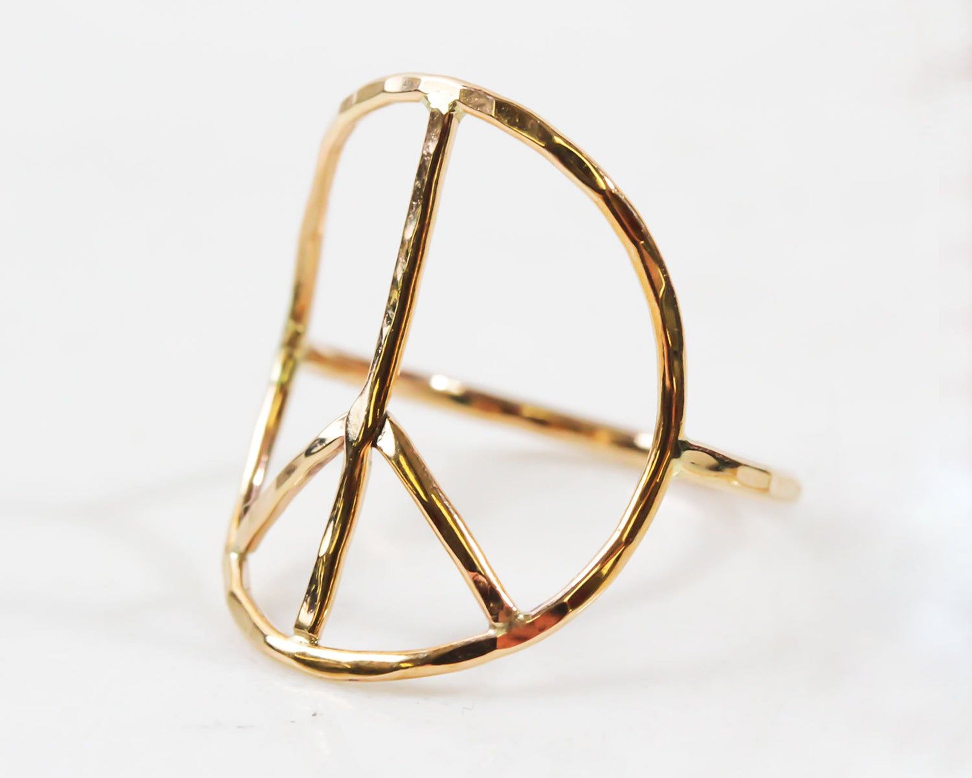 A gold ring in the shape of a peace sign.