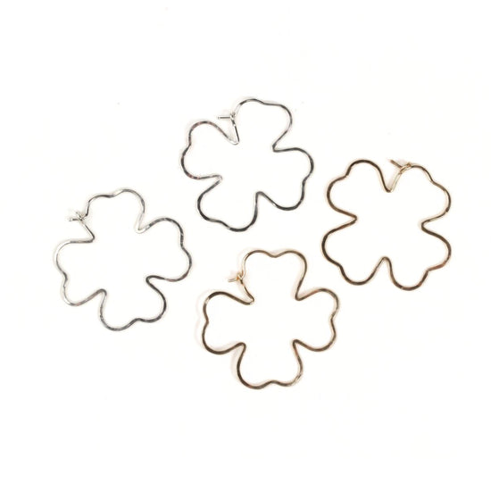 four different wire earrings in the shape of leaves, arranged in a circular pattern.