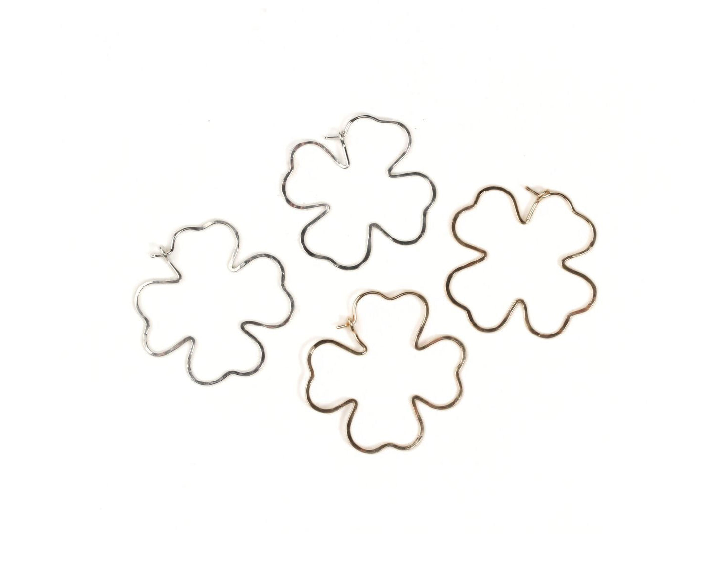 four different wire earrings in the shape of leaves, arranged in a circular pattern.