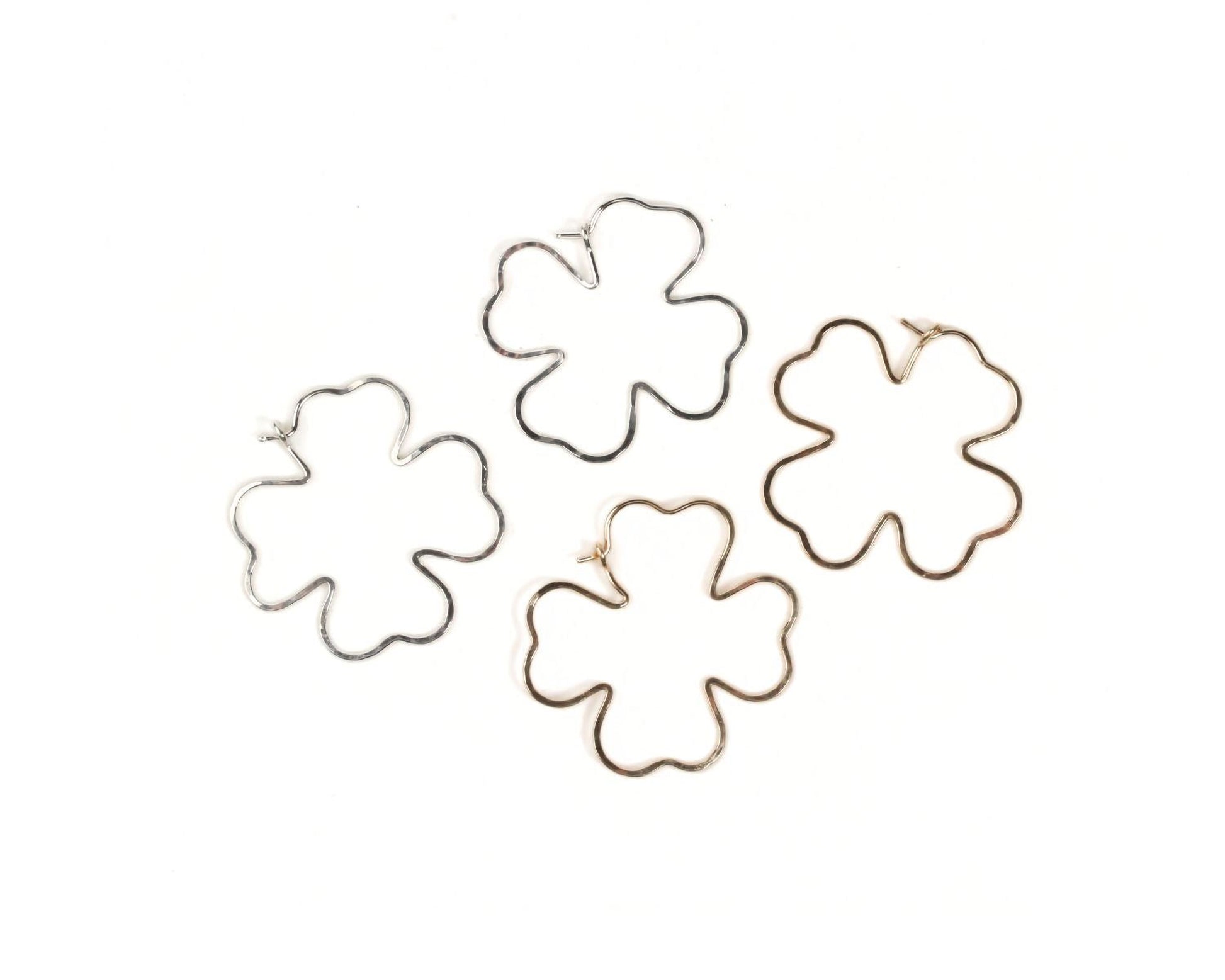 four different wire earrings in the shape of leaves, arranged in a circular pattern.