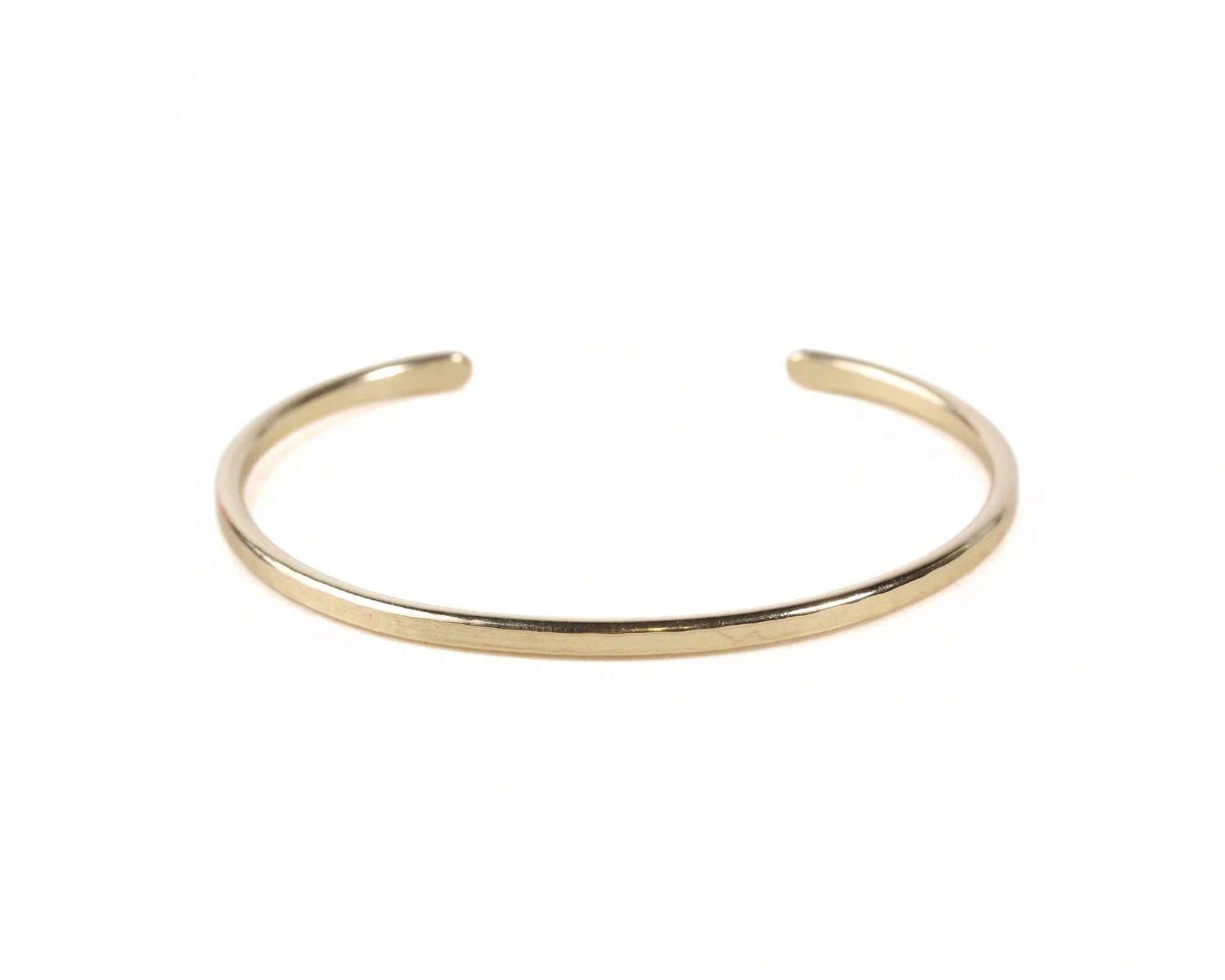 A gold-colored bracelet with a simple, elegant design.