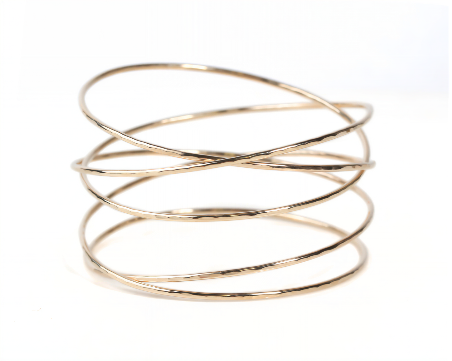 A gold-colored bracelet with multiple overlapping rings, creating a layered and textured appearance.