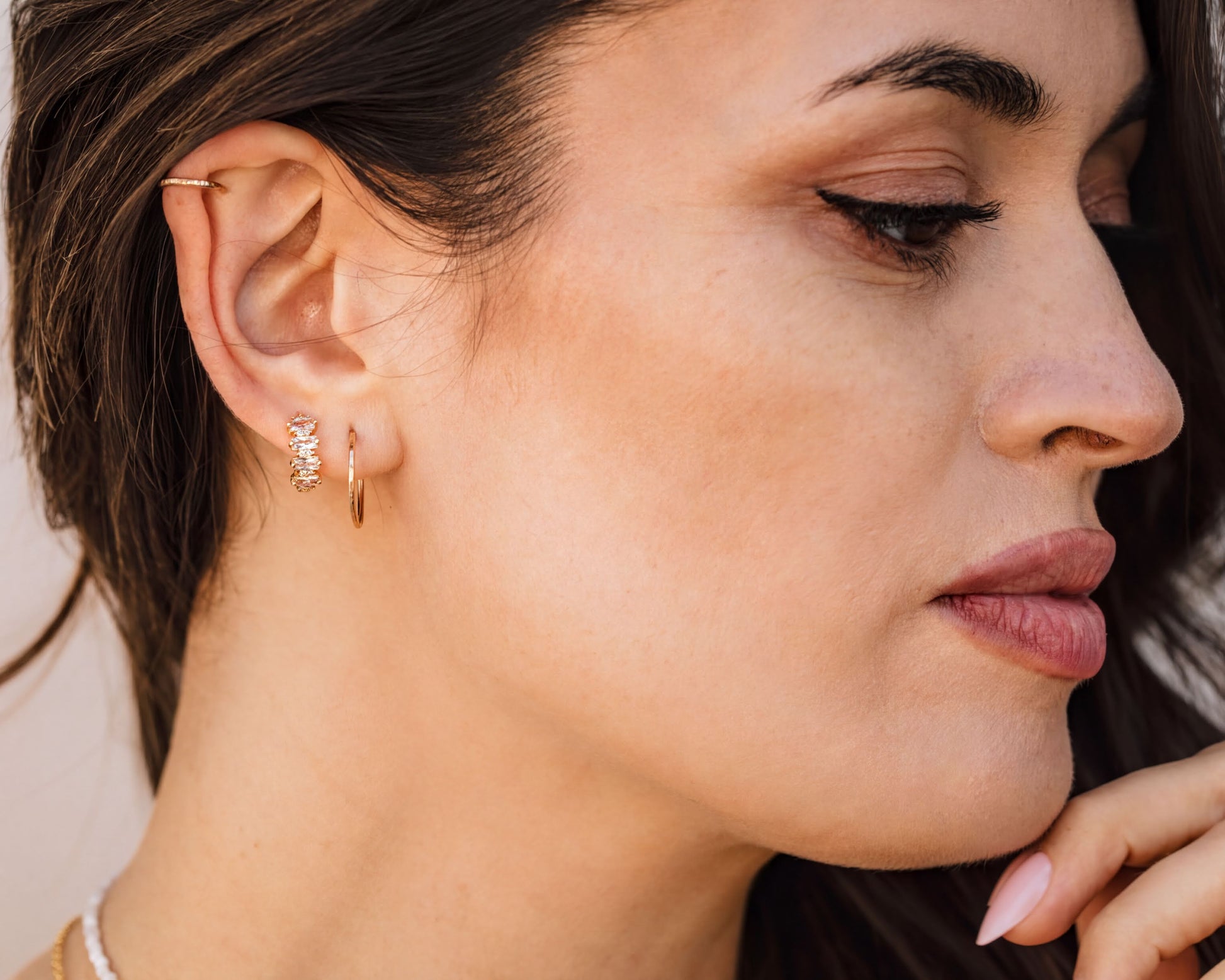 A close-up of a woman's face, focusing on her earrings and lips.