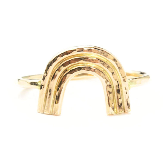 A gold ring with a unique, handcrafted design resembling a rainbow.