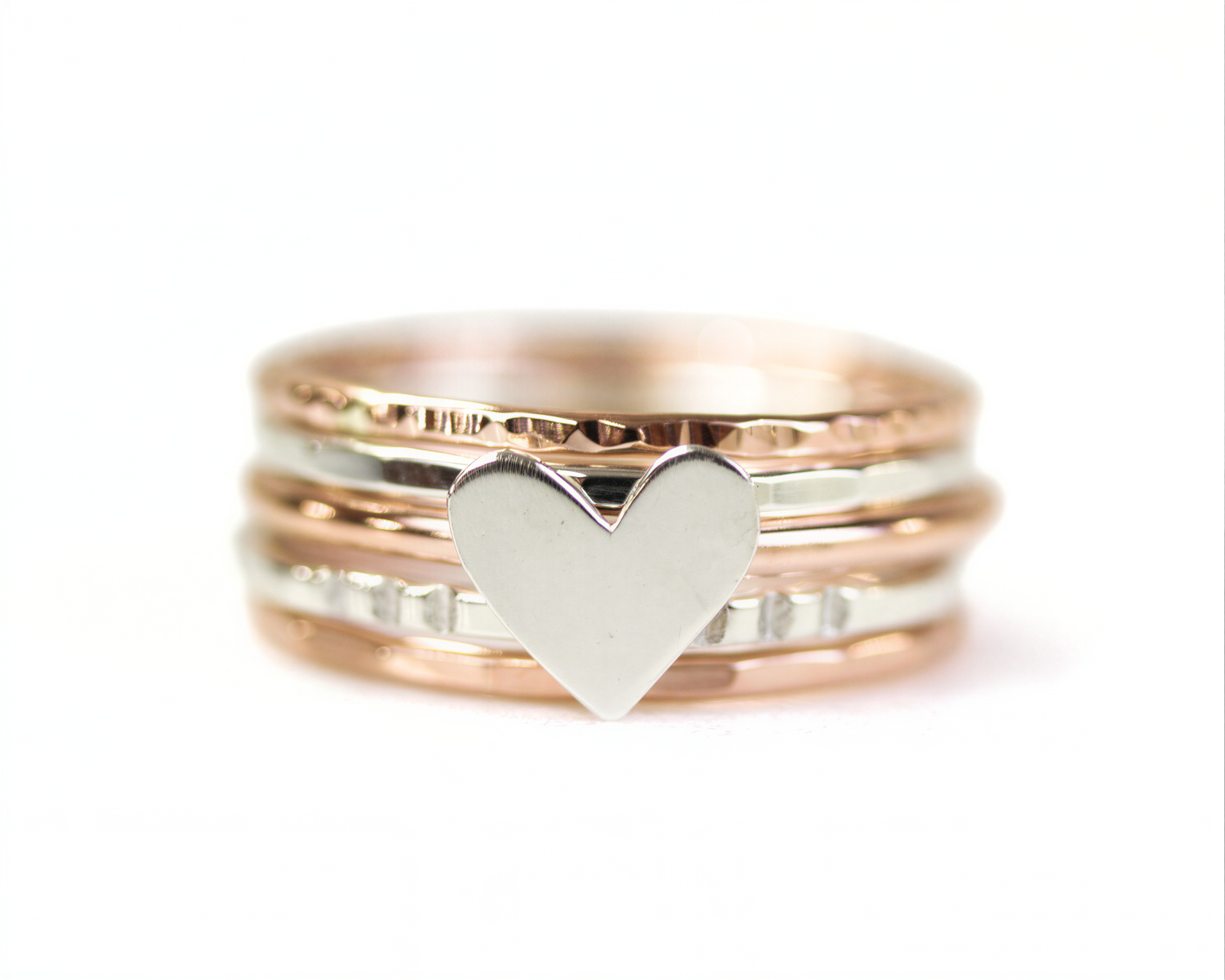 A close-up image of a ring with a heart-shaped charm in the center.