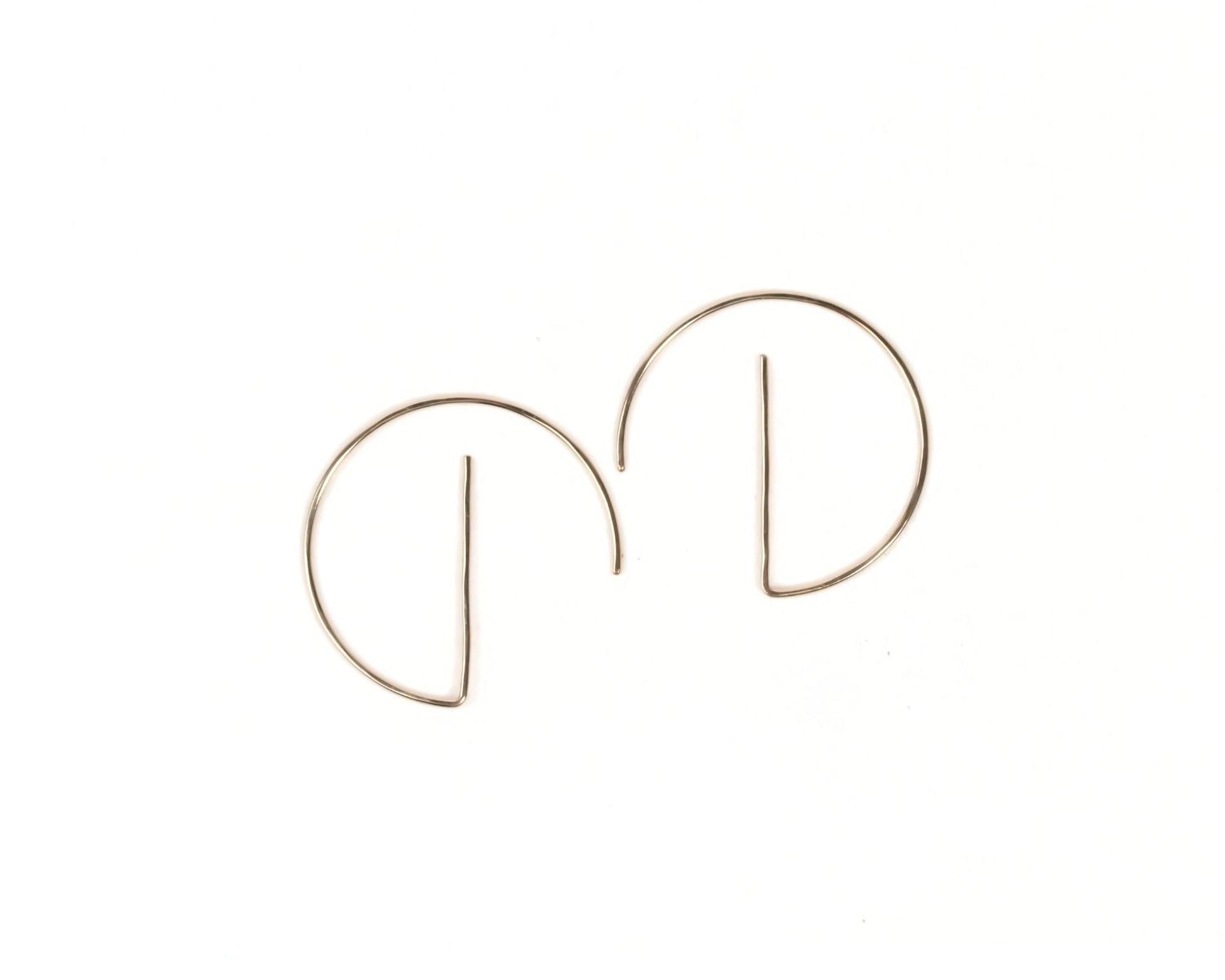 A pair of gold-colored earrings with a unique, circular design.