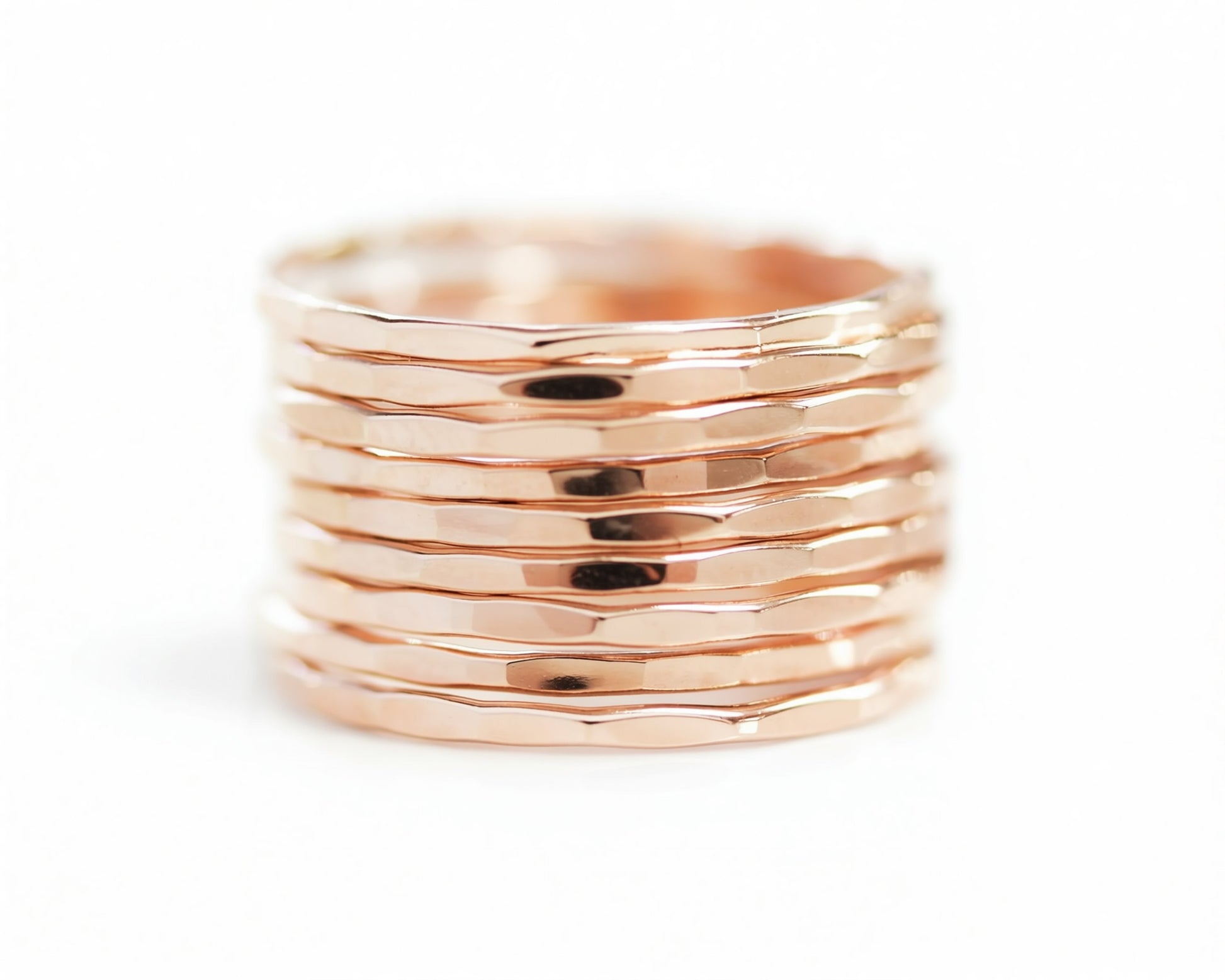 A stack of shiny, metallic rings in a warm, golden color.