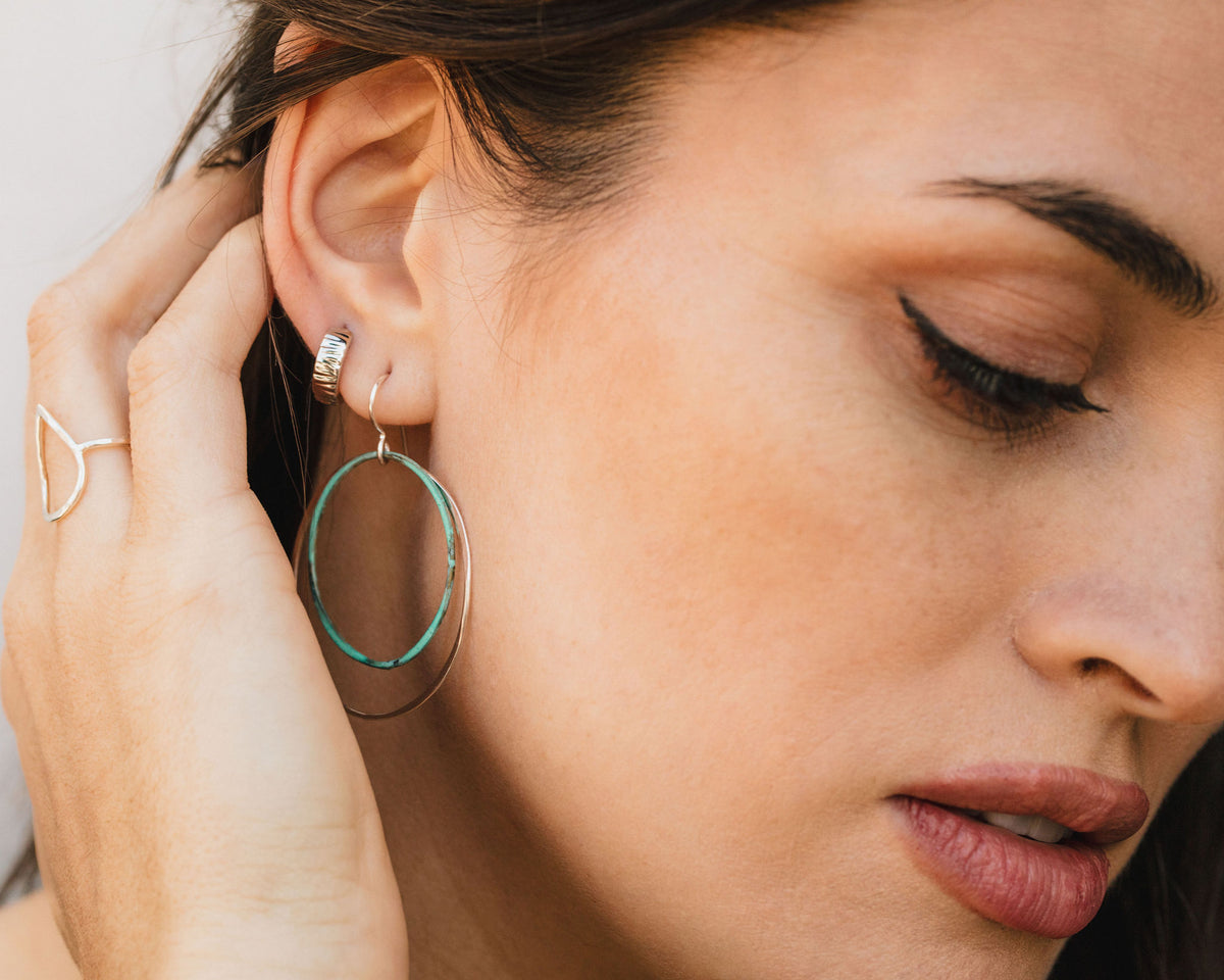 A close-up of a woman's face, focusing on her earrings and lips.