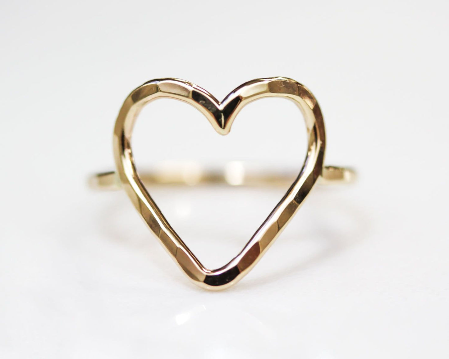 A gold ring with a heart-shaped cutout in the center.