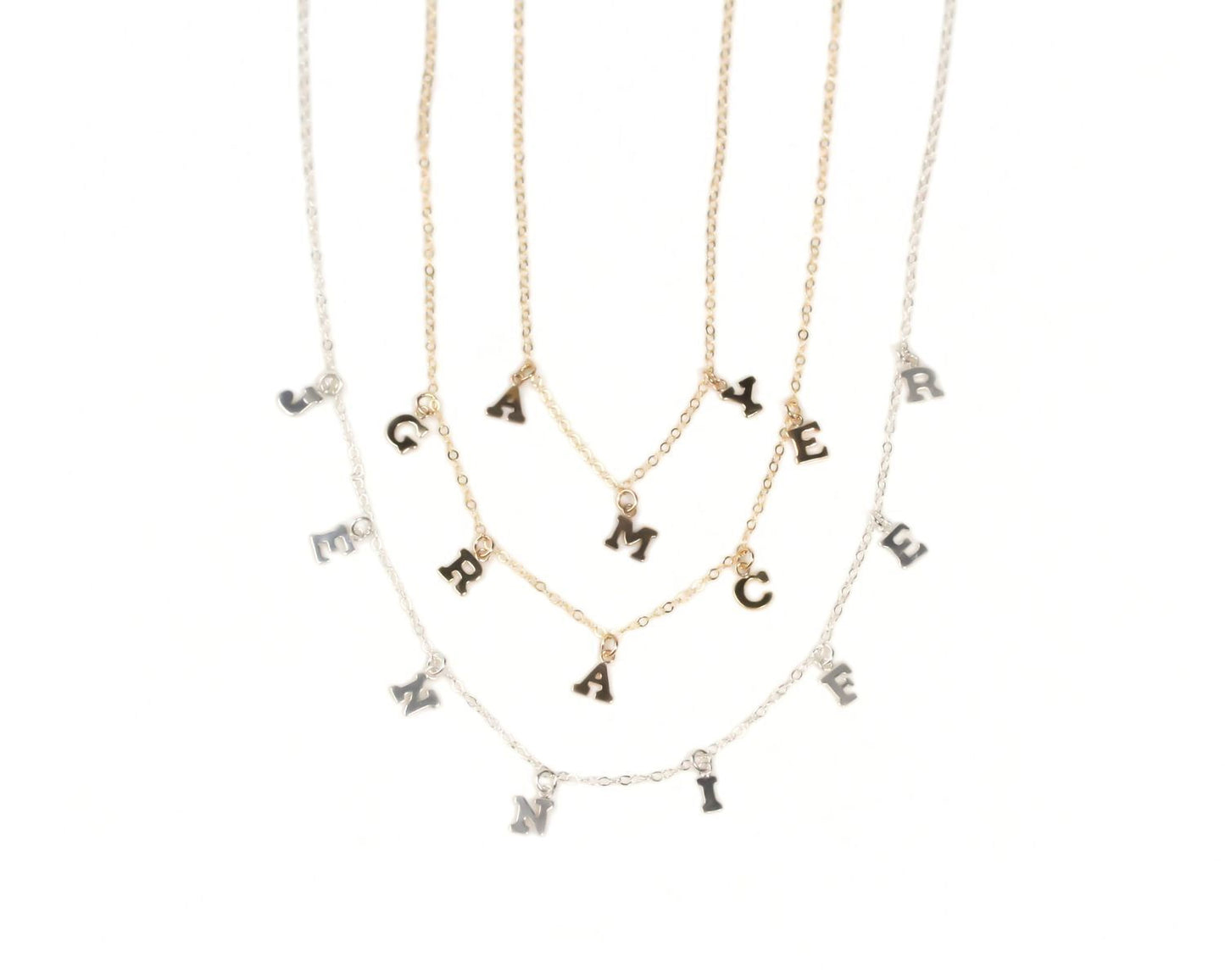 a collection of necklaces with individual letter charms attached to them.