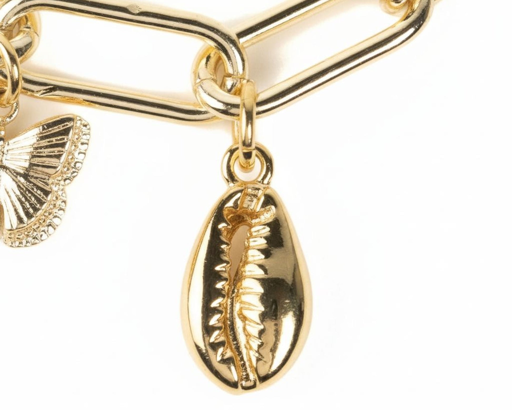 A close-up view of a gold-colored chain with a pendant featuring a shell design and a butterfly charm.