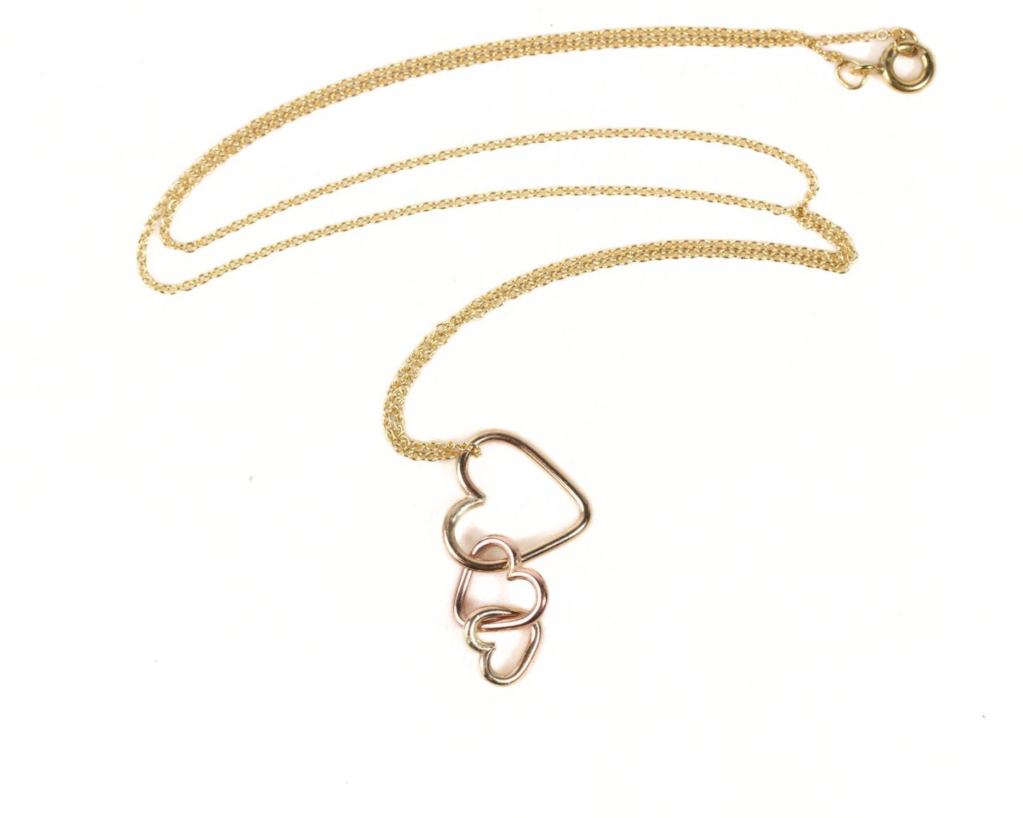 A gold necklace with a pendant featuring three interlocking heart shapes.