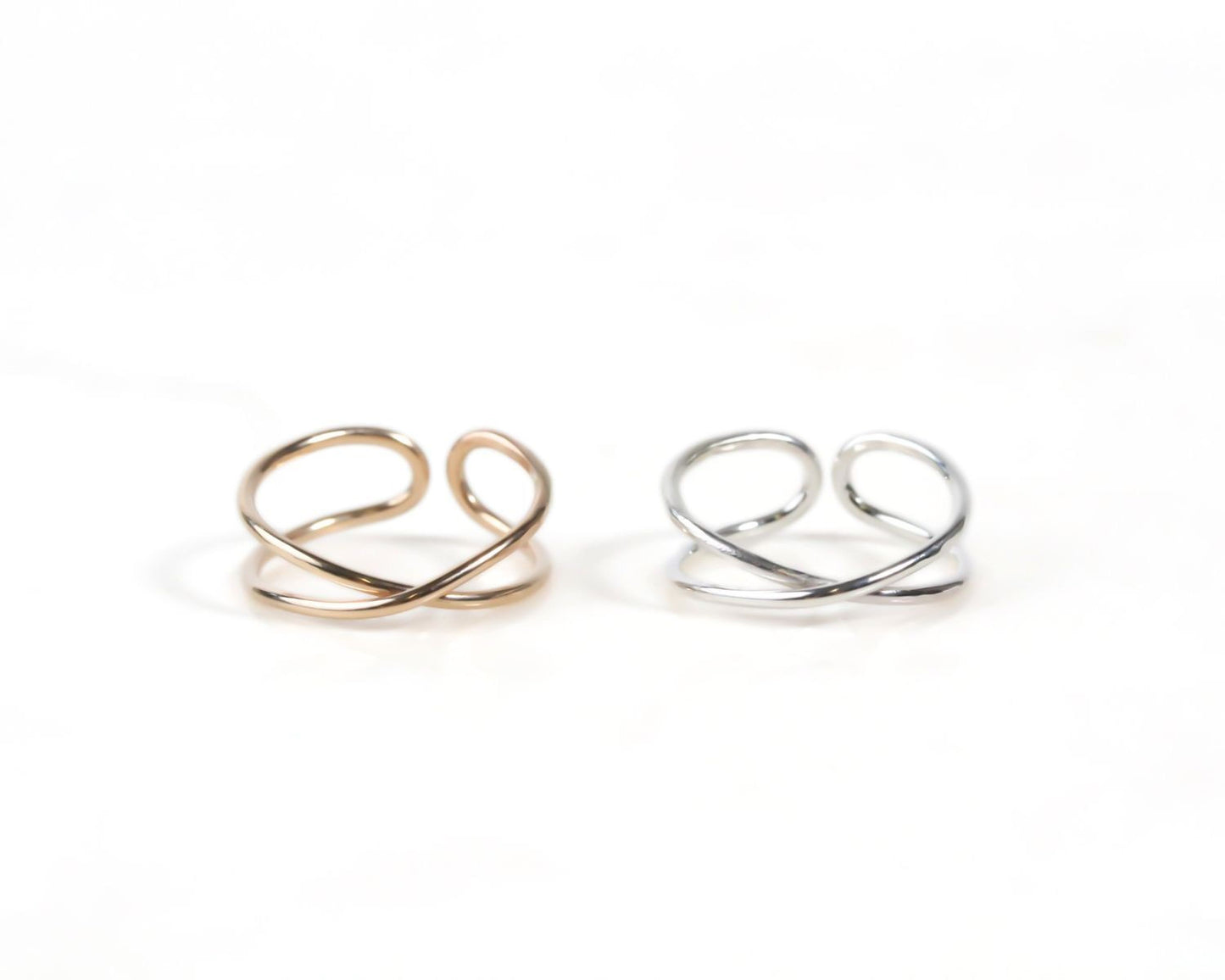 Two rings with twisted designs are placed side by side on a white background.