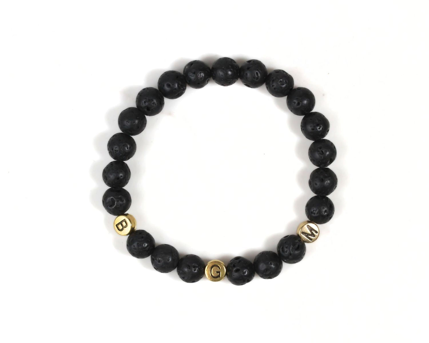 A bracelet made of black beads with gold letters spelling out the word "BGM".