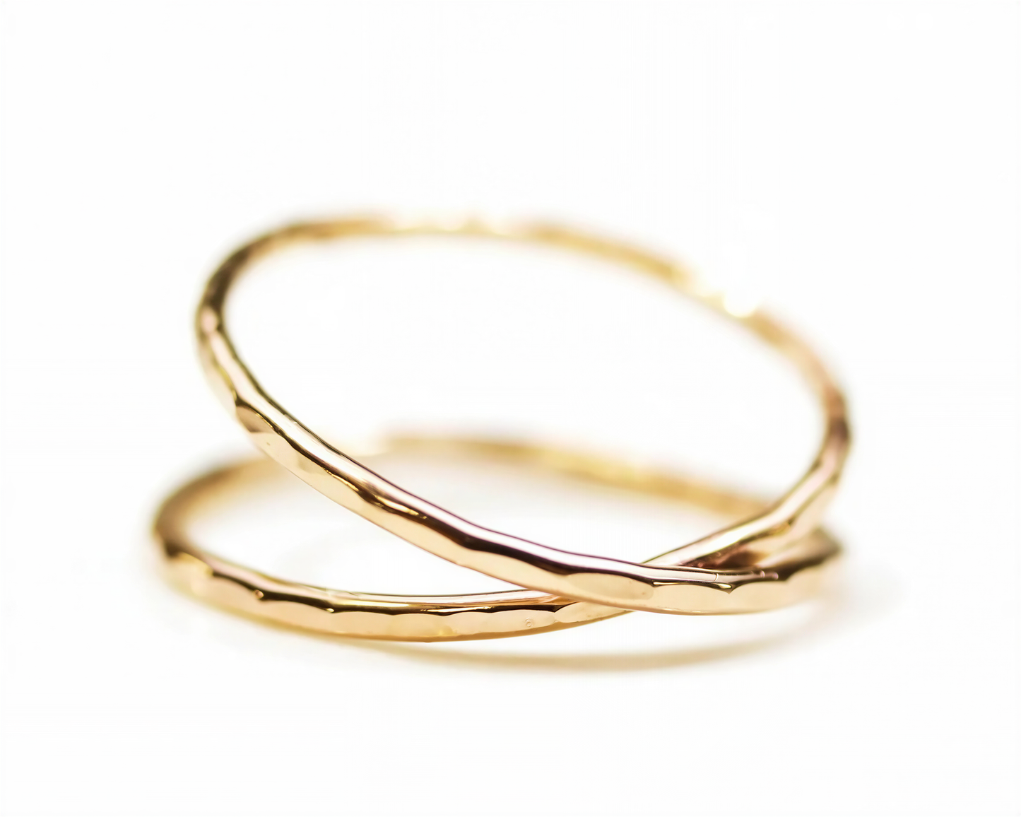 Two gold rings overlapping each other against a white background.