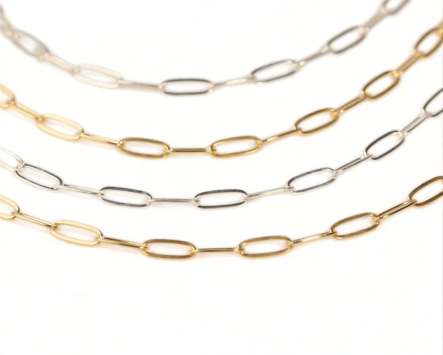 a collection of various colored metal chain necklaces arranged in a row.