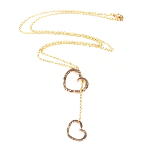 A gold necklace with two heart-shaped pendants hanging from the chain.