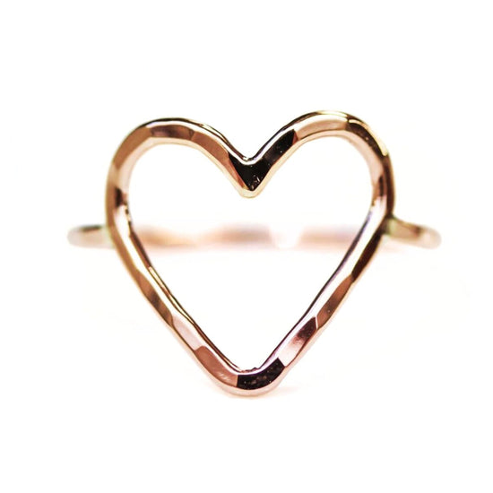 A heart-shaped ring made of a shiny, metallic material.