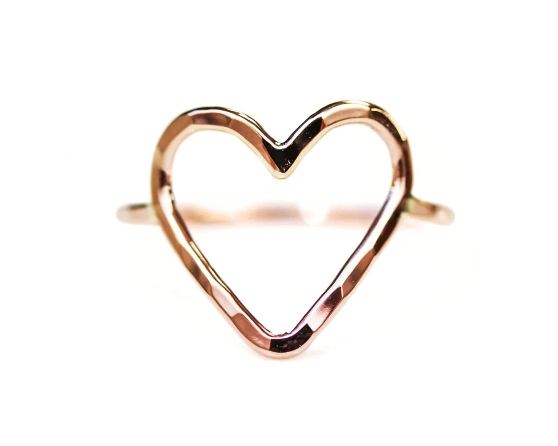 A heart-shaped ring made of a shiny, metallic material.