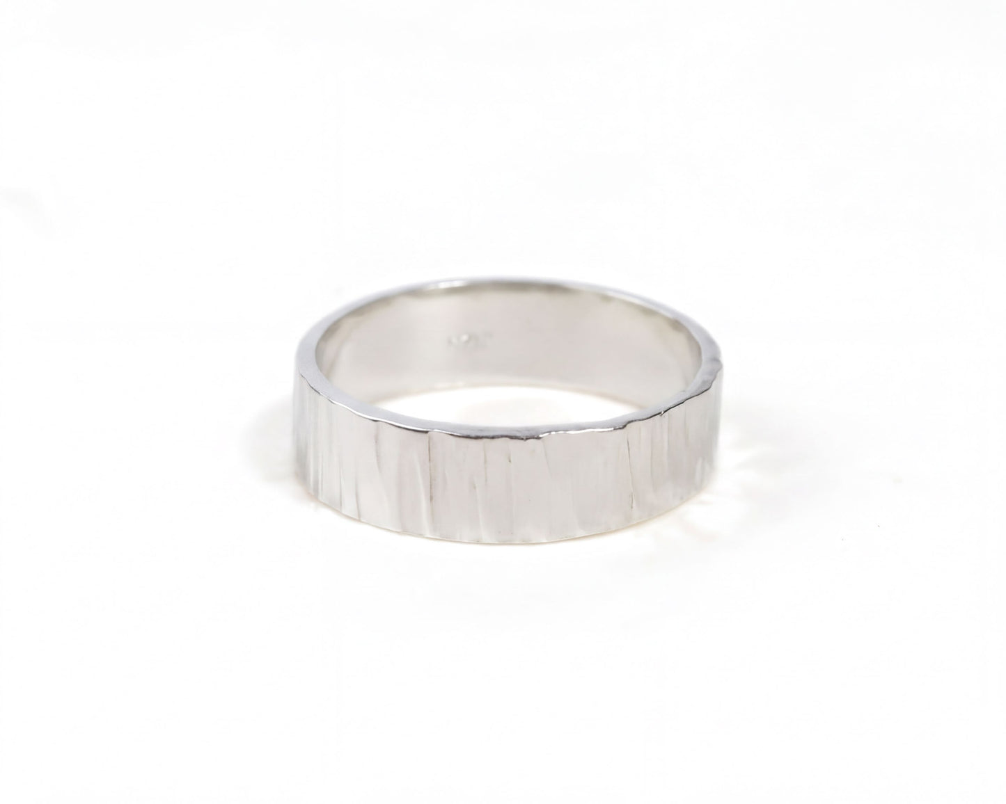 A silver ring with a textured band is shown against a white background.