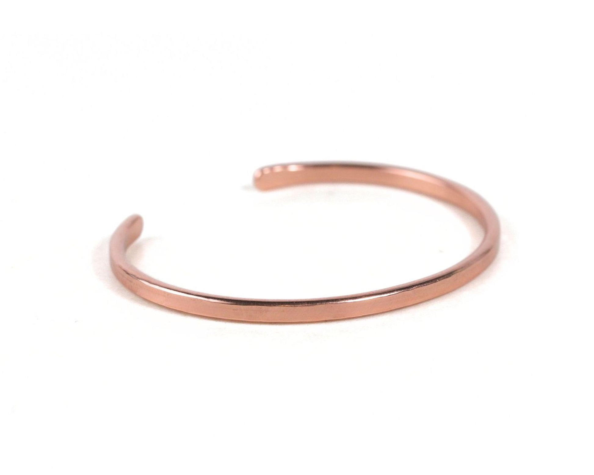 A copper-colored bracelet is shown against a white background.