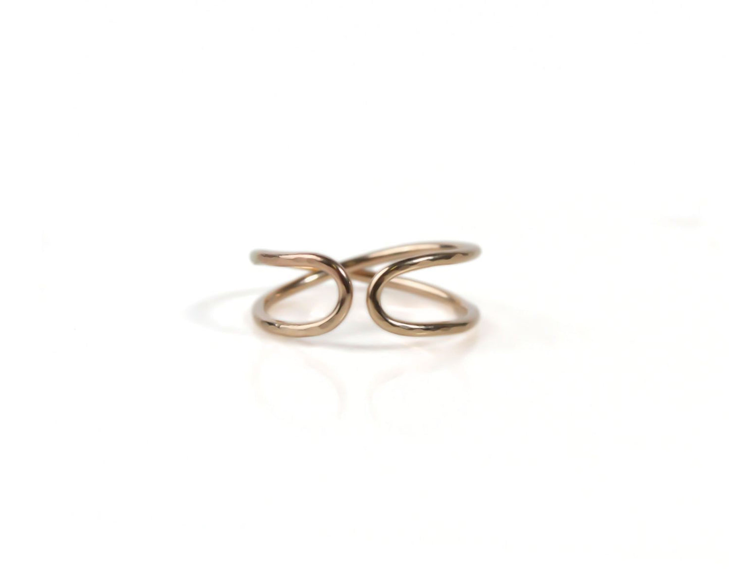 A gold-colored ring with a twisted, overlapping design.