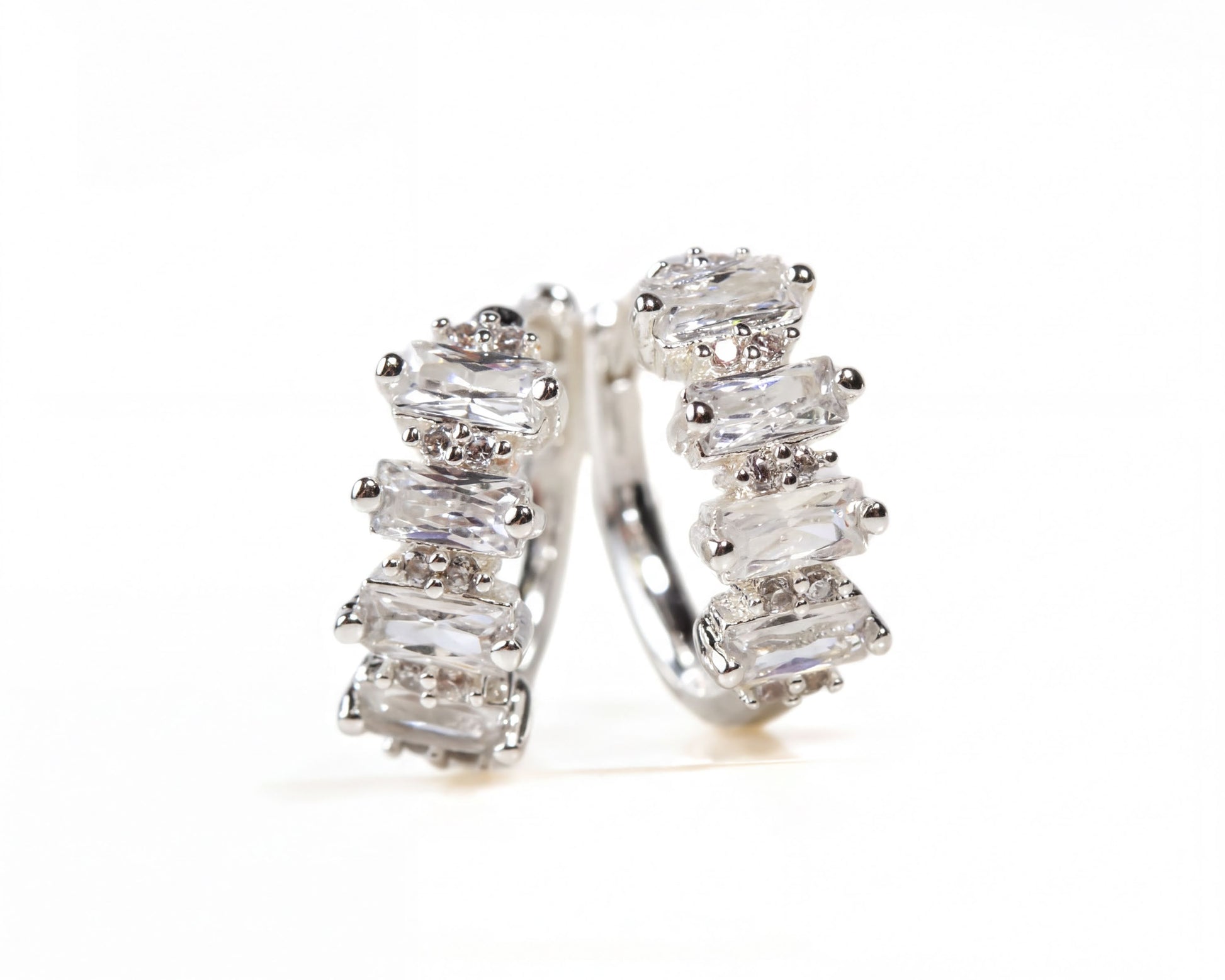 A pair of elegant silver earrings adorned with numerous clear gemstones, creating a sparkling and sophisticated appearance.