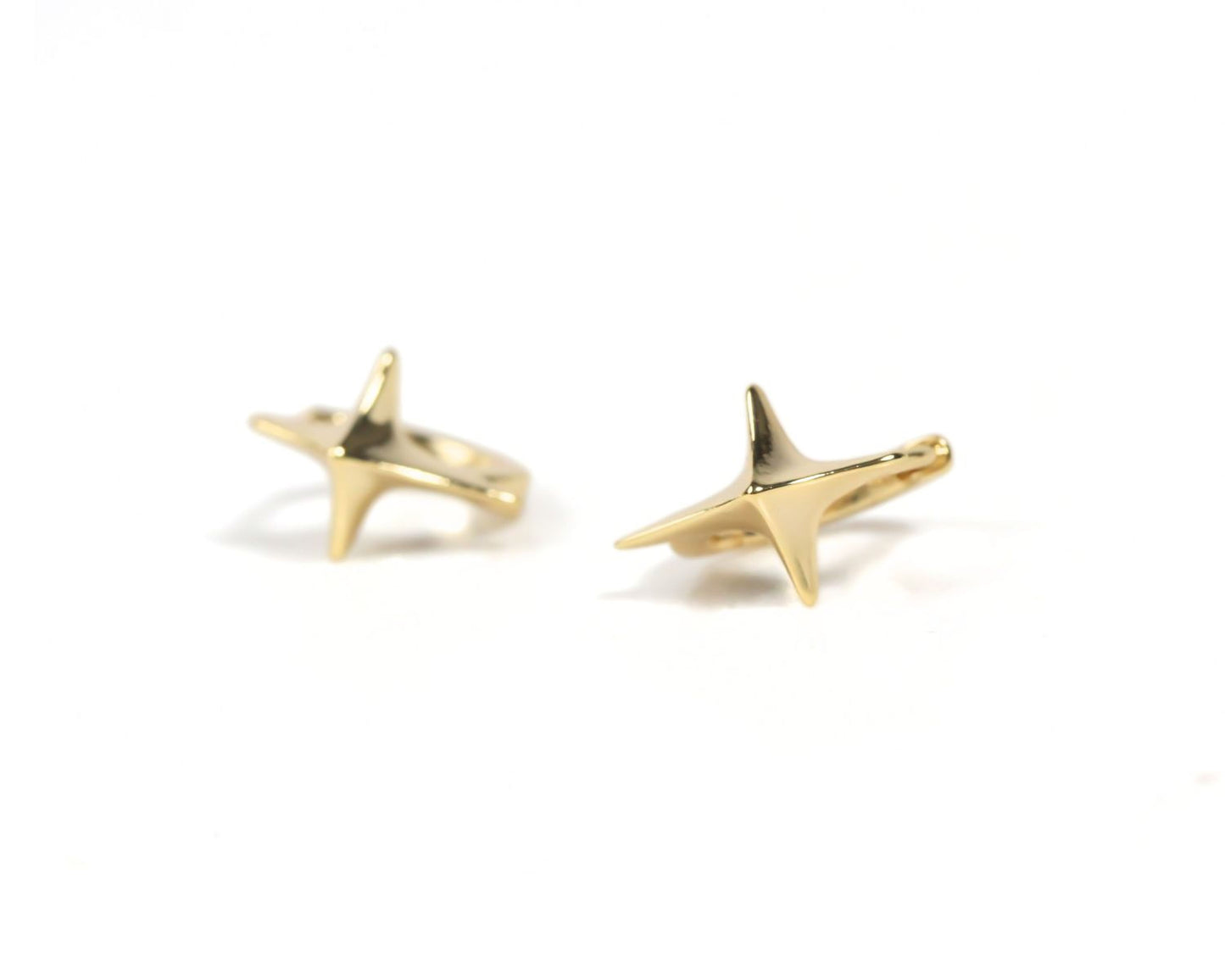a pair of gold-colored earrings with star-shaped designs.