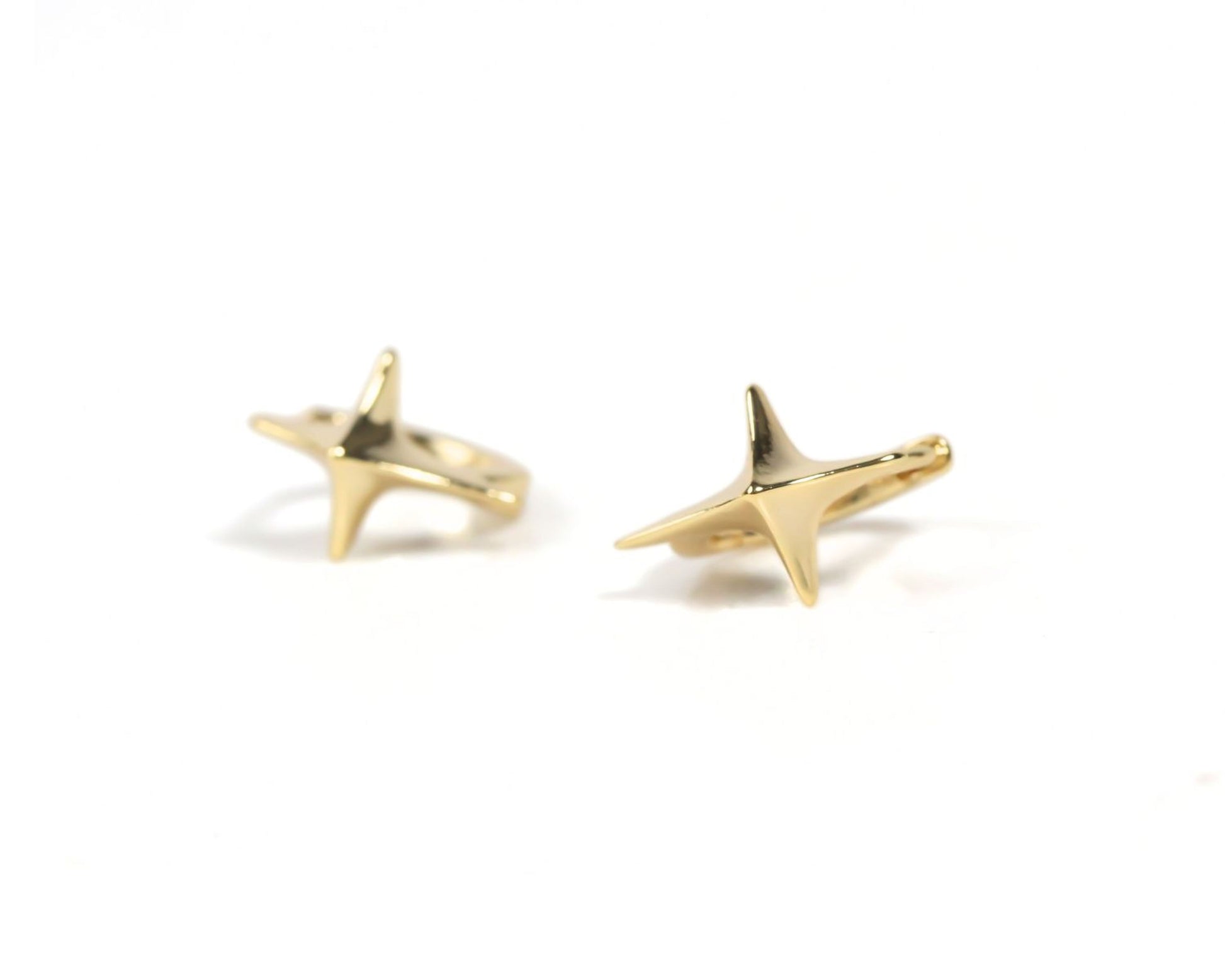 a pair of gold-colored earrings with star-shaped designs.